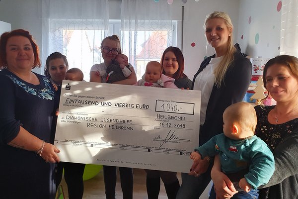 Karen Neumann (dritte v.r.) von der KPS AG überreicht die Weihnachtsspende an Teamleiterin der DJHN-Mutter-Kind-Gruppe Anja Schädler (links) im Beisein von Bewohnerinnen mit ihren Kleinkindern. Karen Neumann (dritte v.r.) von der KPS AG überreicht die Weihnachtsspende an Teamleiterin der DJHN-Mutter-Kind-Gruppe Anja Schädler (links) im Beisein von Bewohnerinnen mit ihren Kleinkindern.